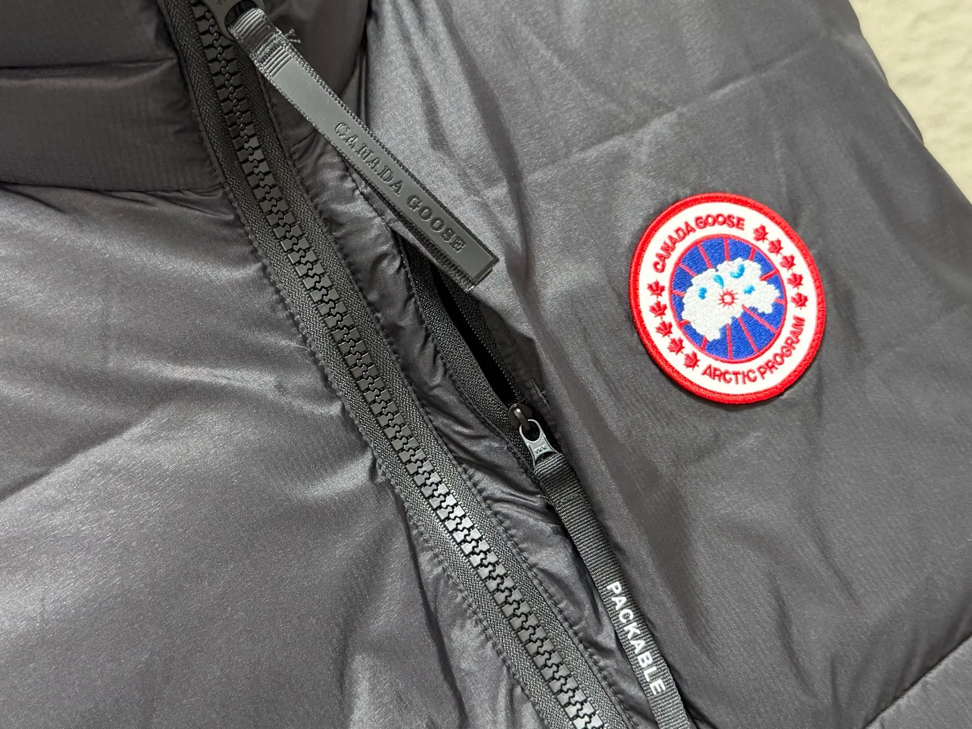 (High-quality) 𝘾𝘼𝙉𝘼𝘿𝘼 𝙂𝙊𝙊𝙎𝙀/Canada Goose Stand Collar Lightweight Down Vest ●Selected tear-proof textured fabric, fine plaid texture, wind-resistant and durable, taking into account light weight and toughness. ●Horizontal quilting segmented down lock technology, the down is evenly filled, not easy to run away, fluffy and not bloated. ●Classic red and black round emblem embroidery, the brand logo is exquisite and three-dimensional, low-key and high-end. ●High stand-up collar and windproof design, YKK zippers are smooth and durable, and the drawstring at the hem can be tightened freely to lock in warmth. ●Practical pockets on both sides make it easy to store small items; the stowable and portable design does not take up space when traveling. ●The cut is loose and neat, not flattering to your body shape. It can be worn alone in spring and autumn or layered with a coat in winter. It is suitable for urban commuting and outdoor travel. COLOUR:Black red label SIZE: S M L XL XXL